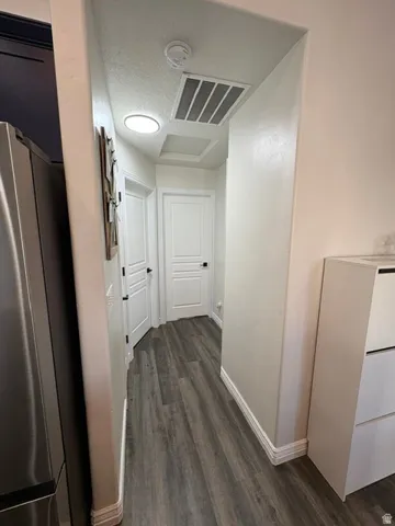 Wood-finish flooring throughout, white interior doors with dark hardware, recessed ceiling lighting, and crisp white baseboards