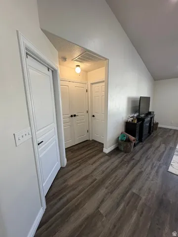 Wood-finish flooring throughout, white paneled doors with black hardware, recessed lighting, and sloped ceiling
