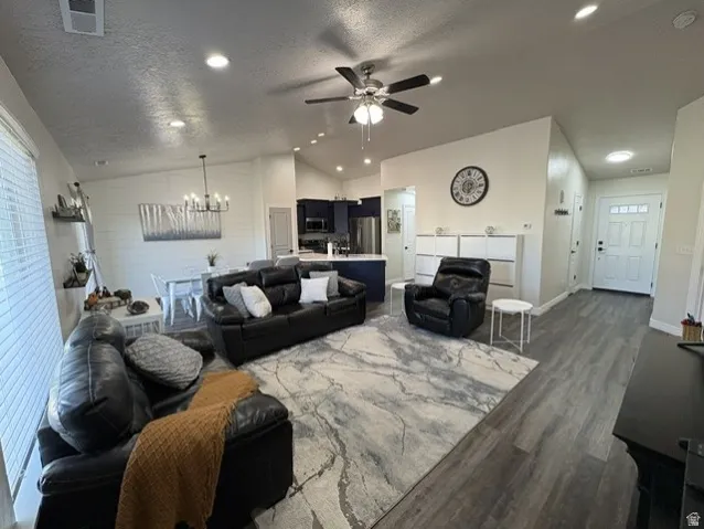 Open-concept living space with wood-finish flooring, recessed lighting, and a ceiling fan