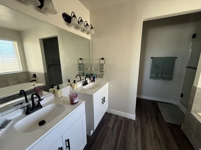 Dual vanity with white cabinetry, matte black hardware, and integrated sinks
