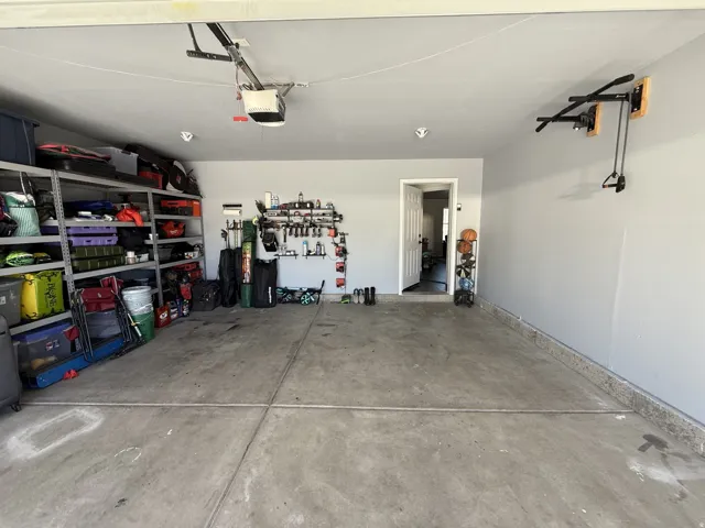 Concrete flooring, painted walls, overhead garage door opener, recessed lighting