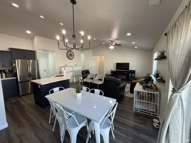 Open-concept living space featuring wood-finish flooring, recessed lighting, and a vaulted ceiling