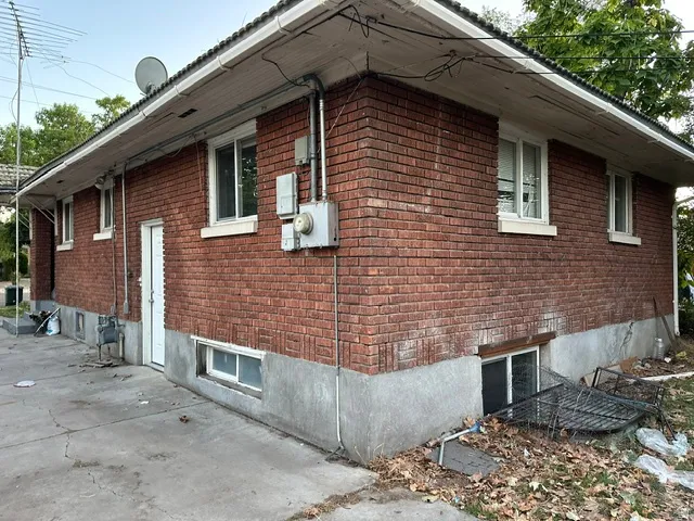 Red brick exterior with white window frames and a concrete foundation