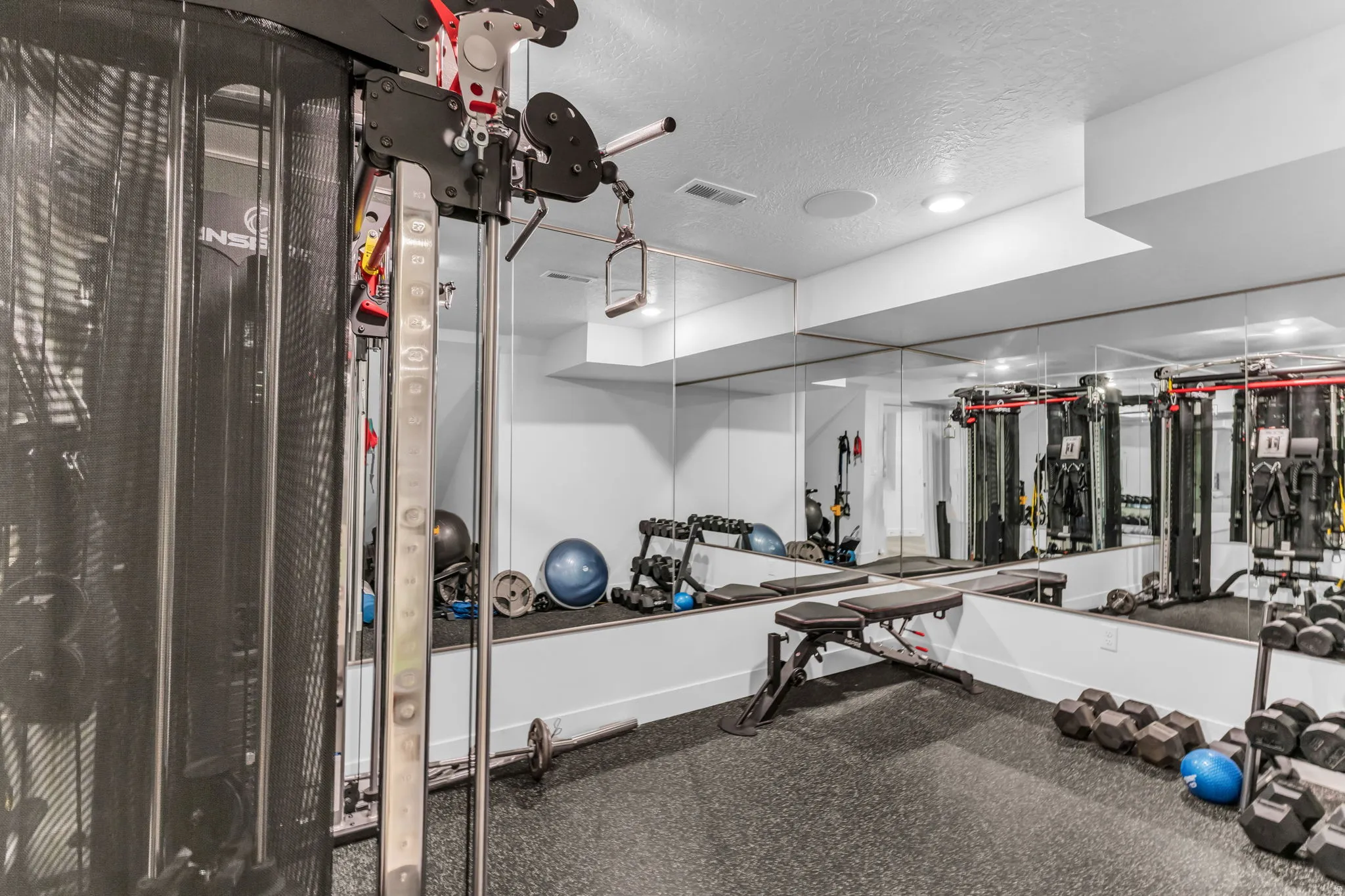 Dedicated fitness space featuring full-wall mirrors and recessed lighting