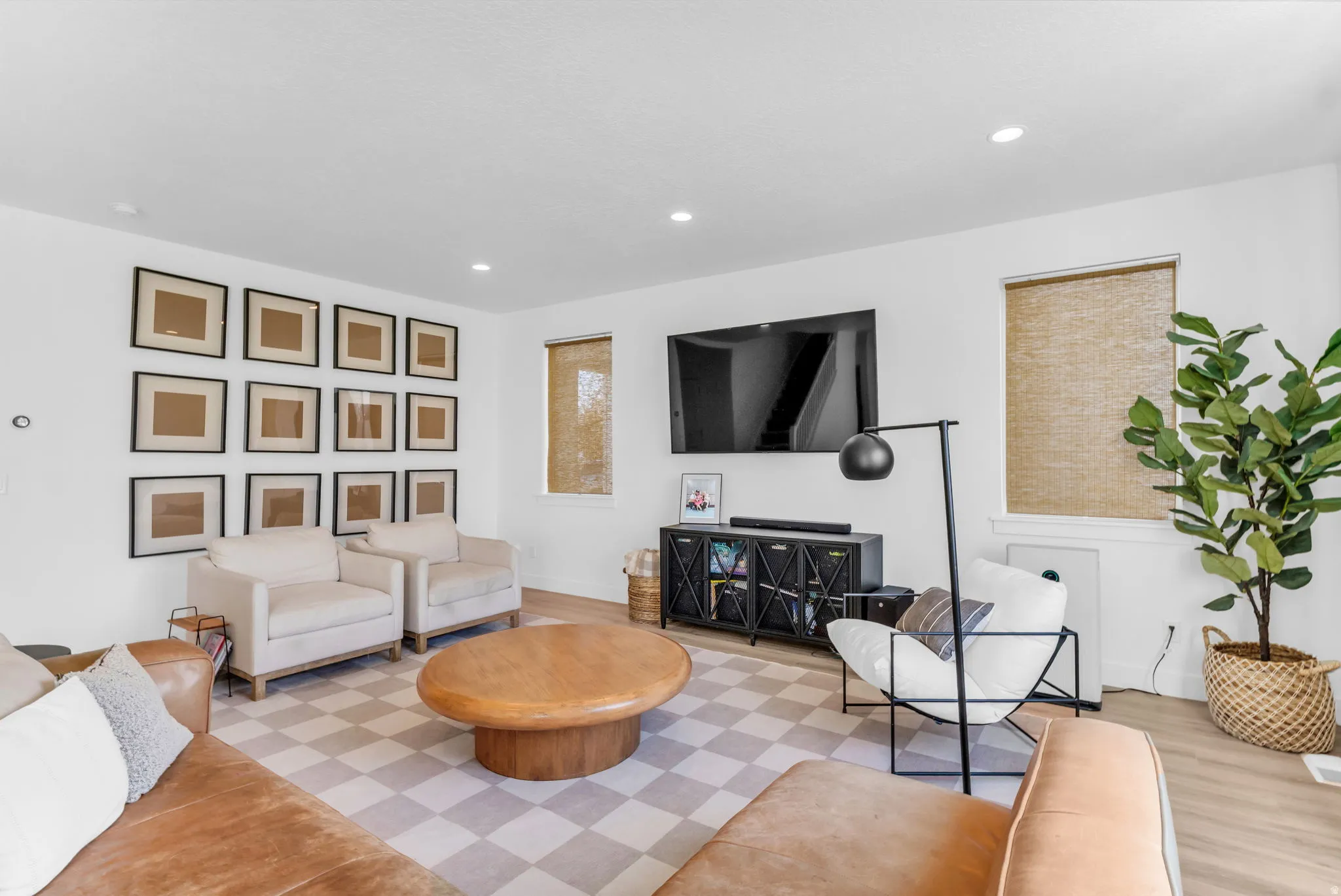 Recessed lighting illuminates the open-concept living space with wood-finish flooring