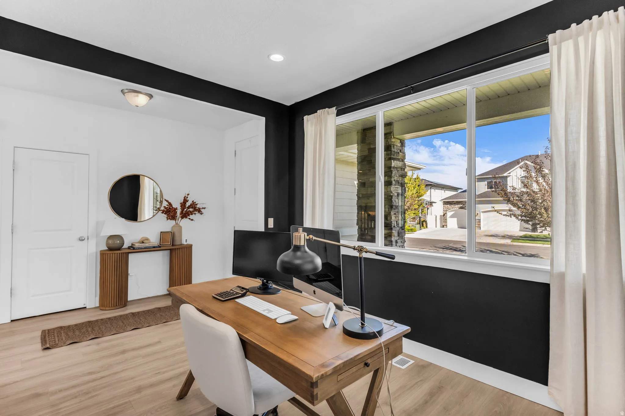 Recessed lighting illuminates wood-finish flooring