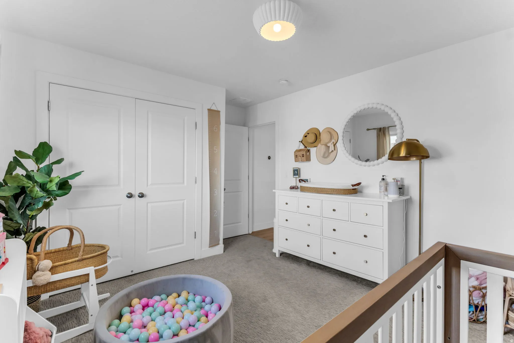 White paneled bi-fold closet doors, white walls, and a round, textured ceiling light fixture