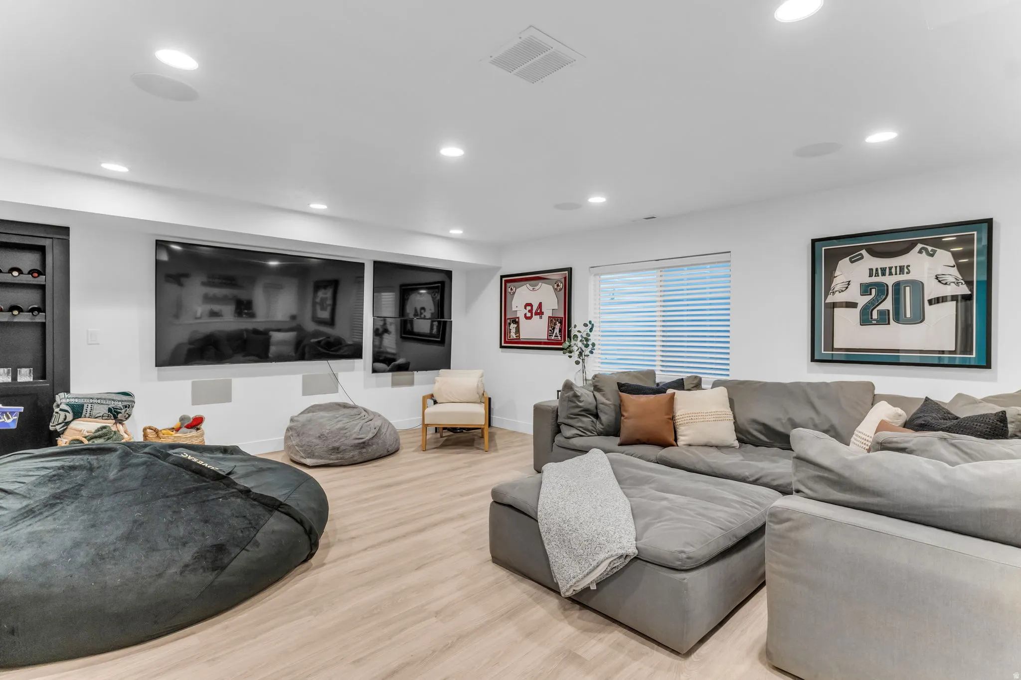 Recessed ceiling lighting, wood-finish flooring, built-in shelving, and a window with blinds