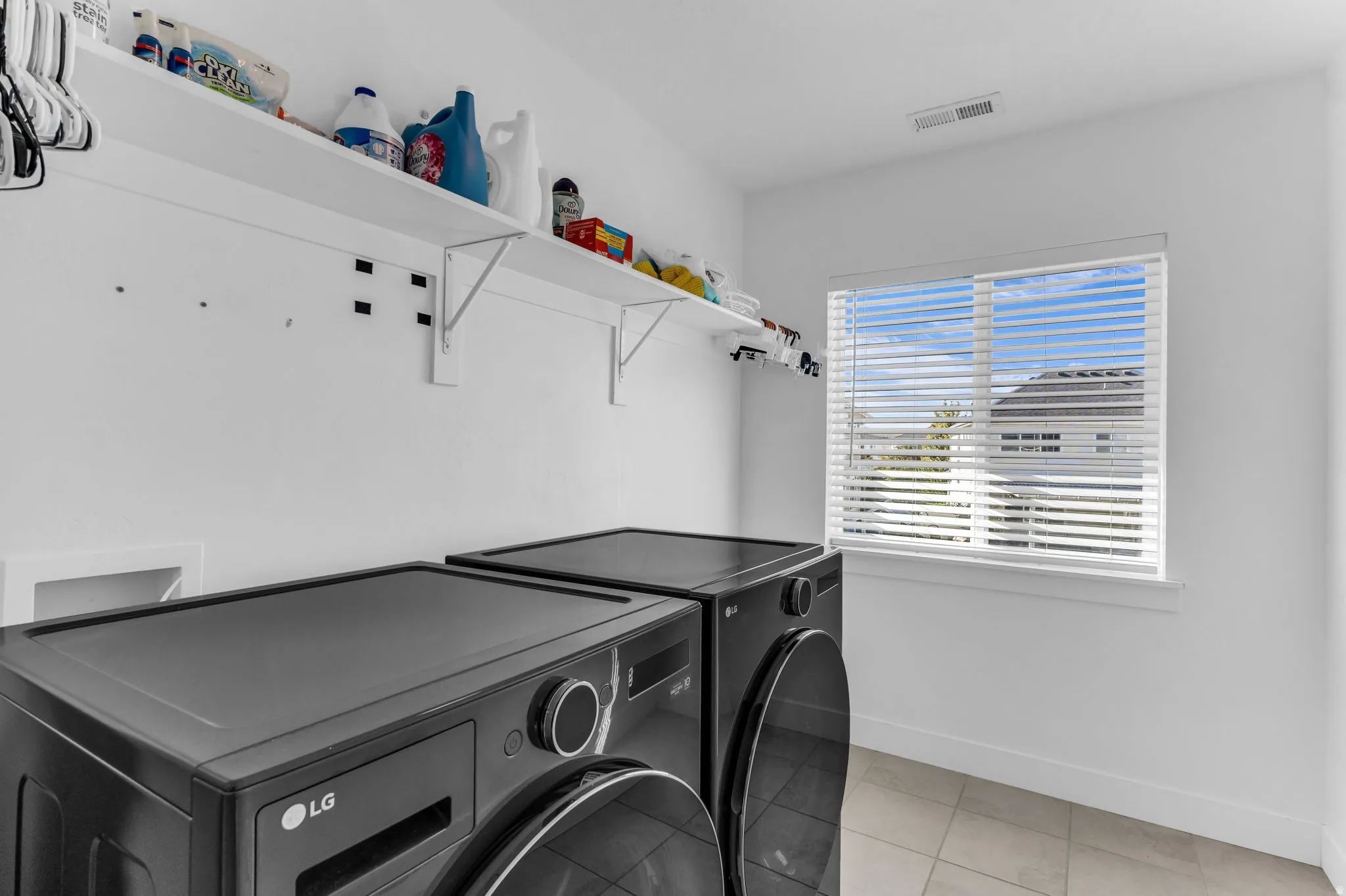 Laundry area with a window, white walls, and built-in shelving