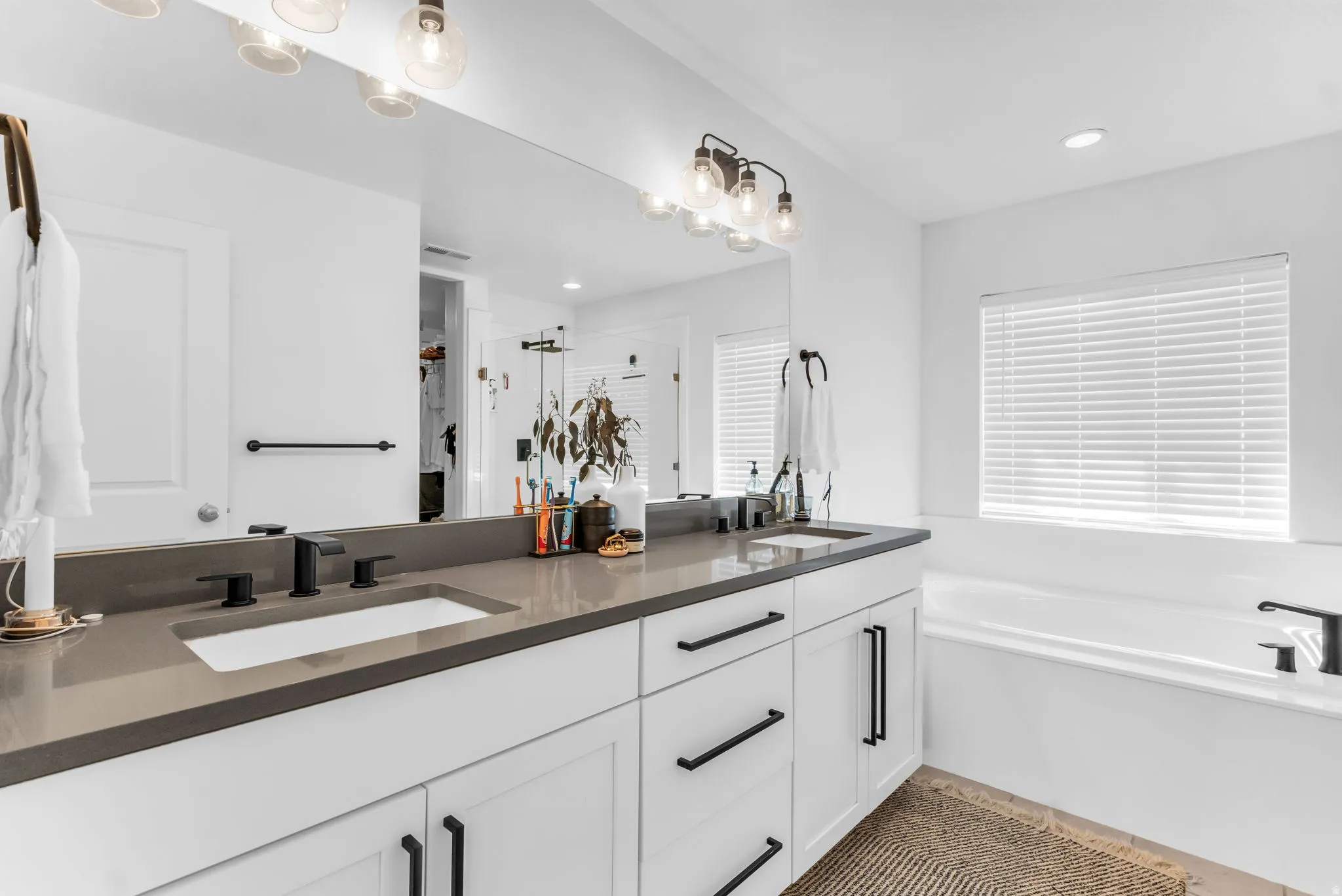Double vanity with rectangular undermount sinks, dark countertops, and matte black fixtures
