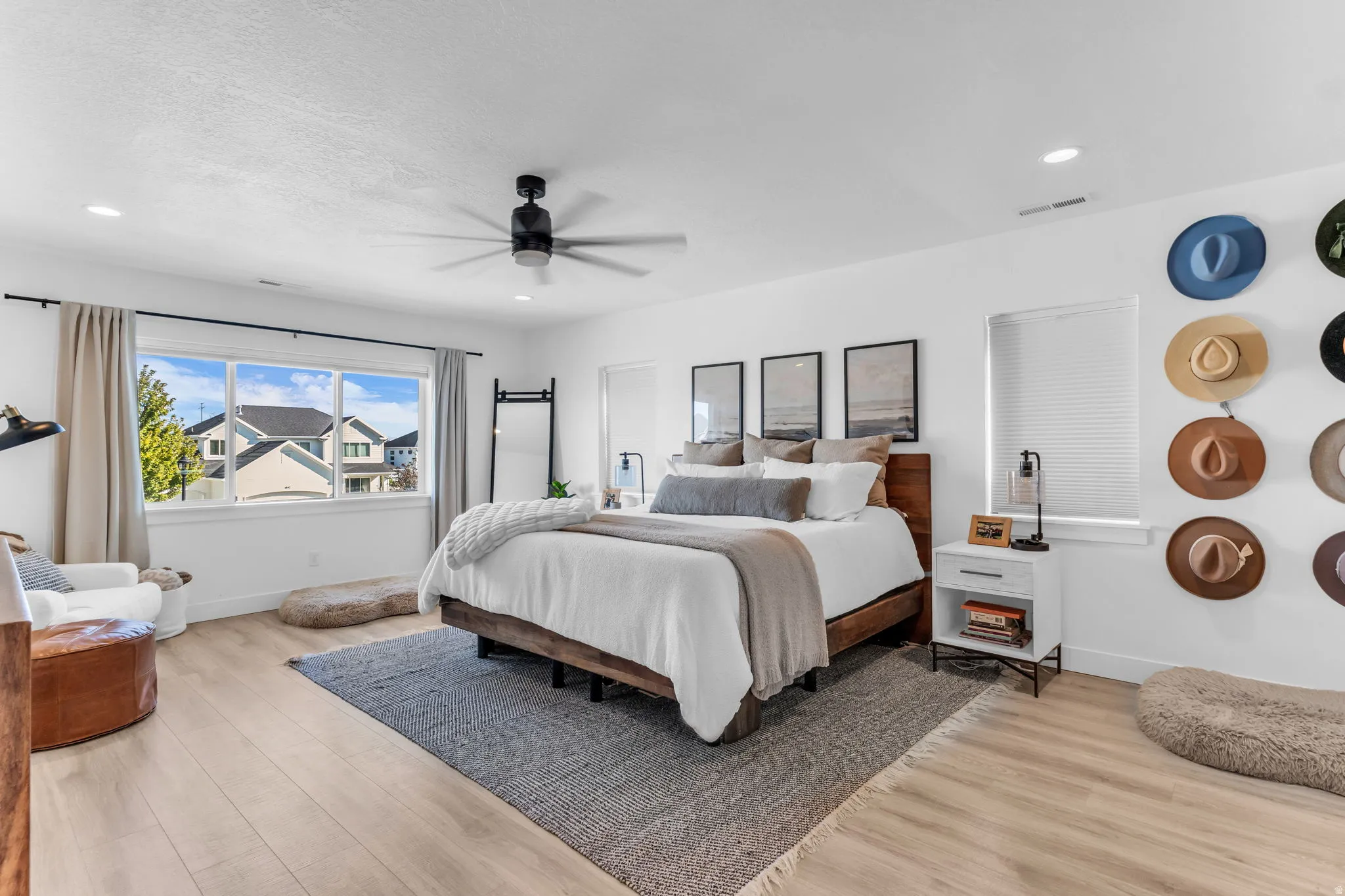 Spacious room featuring wood-finish flooring, large windows, recessed lighting, and a ceiling fan