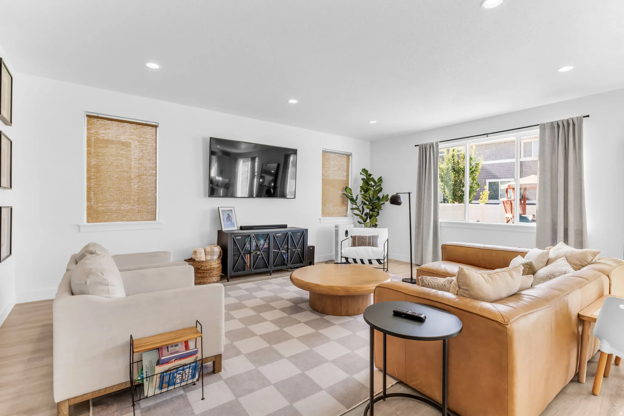 Recessed lighting throughout, wood-finish flooring, and multiple windows with roller shades