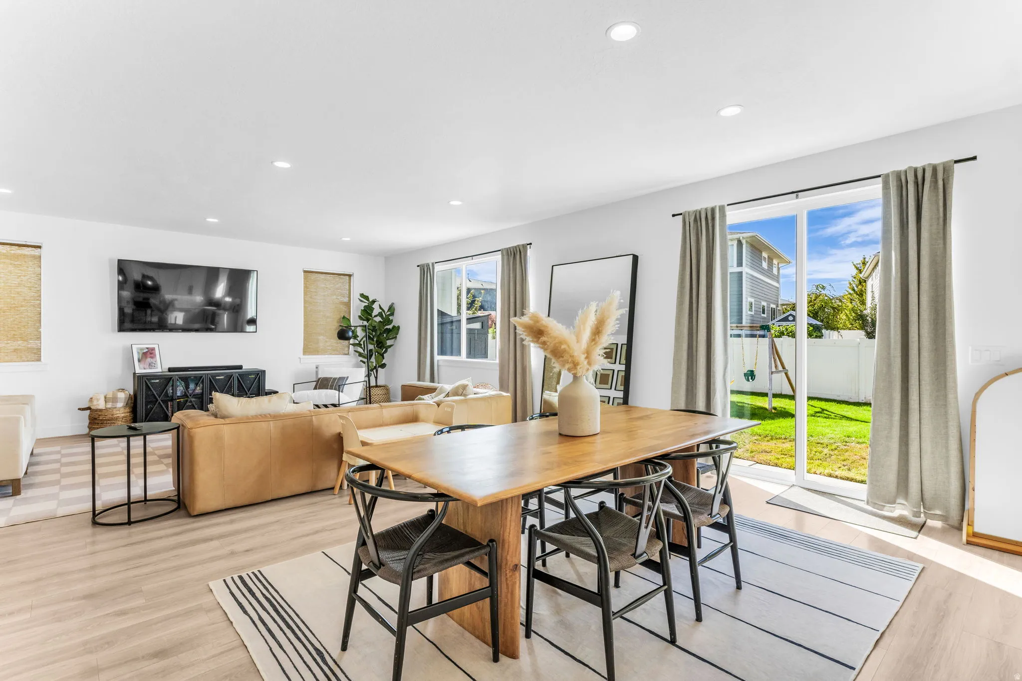 Open concept living area with recessed lighting, wood-finish flooring, and white walls