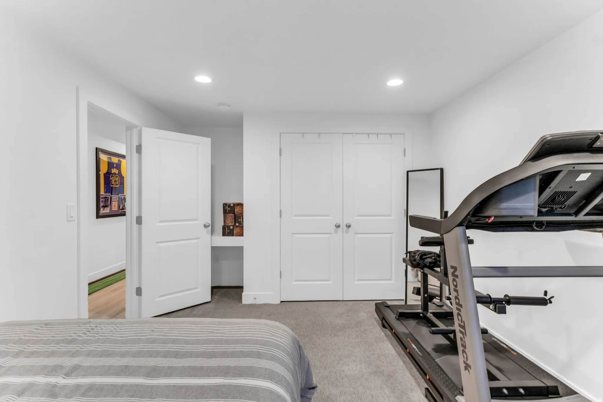 Recessed lighting, painted white walls, built-in desk, and double bifold closet doors