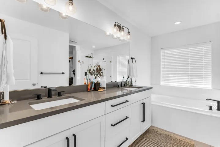 Double vanity with rectangular undermount sinks, dark countertops, and matte black fixtures
