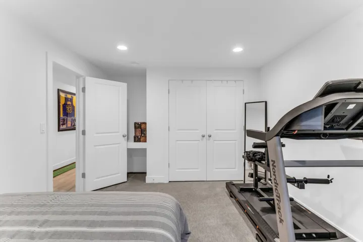 Recessed lighting, painted white walls, built-in desk, and double bifold closet doors