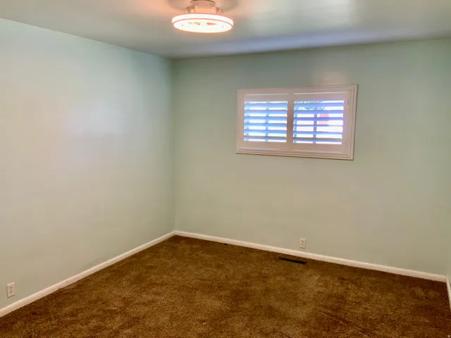 Recessed window with white plantation shutters and trim