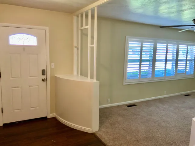 Entryway featuring a decorative transom window, wood-finish flooring, and built-in partition wall