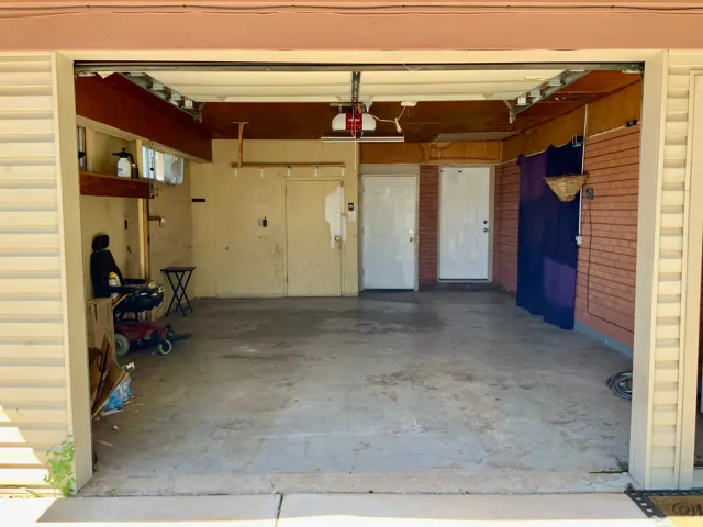 Two white interior doors, exposed brick wall, and concrete flooring