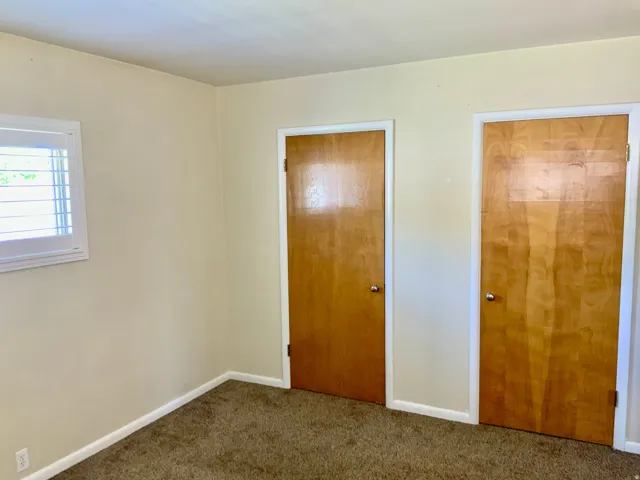 Plantation shutters, two wood-finish interior doors, and neutral wall tones