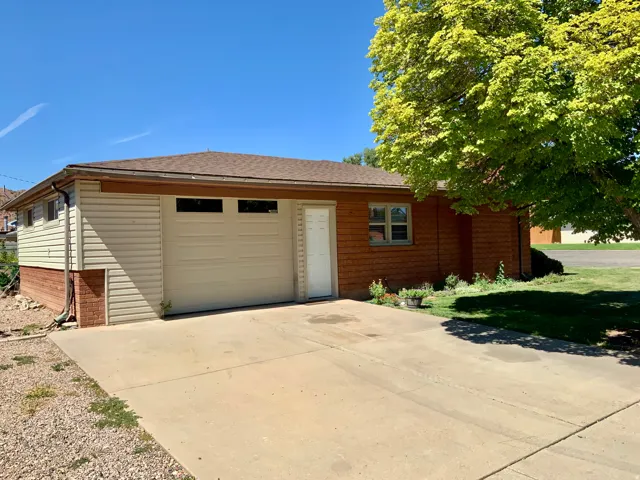 Concrete driveway with an attached garage featuring an overhead door