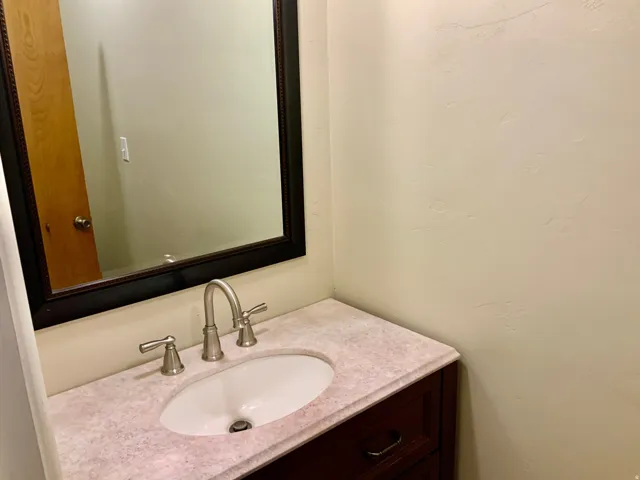 Vanity with a light-colored countertop, oval undermount sink, and brushed nickel faucet