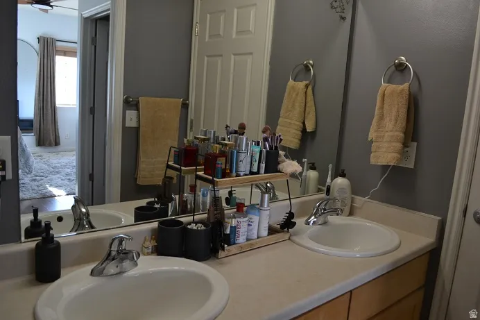 Dual undermount sinks set within a light-toned countertop, featuring chrome faucets and a large vanity mirror
