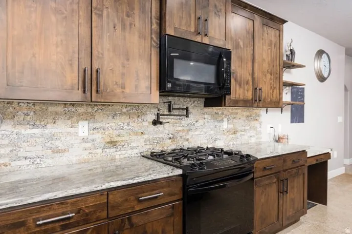 Custom wood cabinetry paired with light-toned countertops and a full tile backsplash
