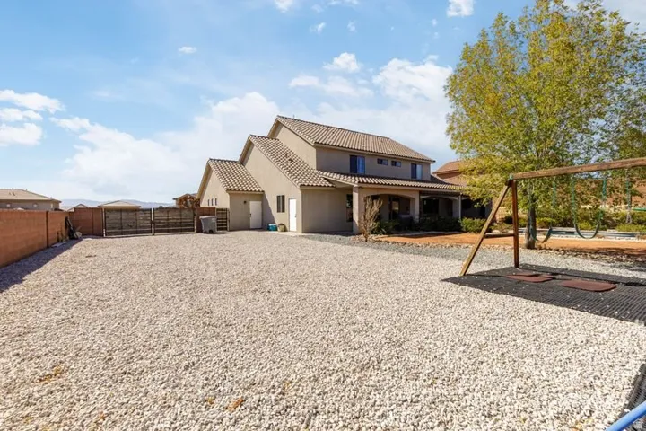 Two-story stucco exterior with a tiled roof, covered patio, and attached two-car garage