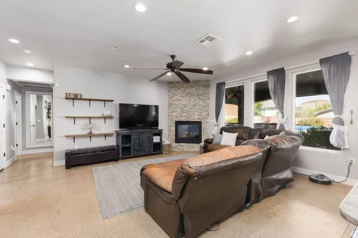 Living area featuring light-toned flooring, recessed lighting, and a ceiling fan