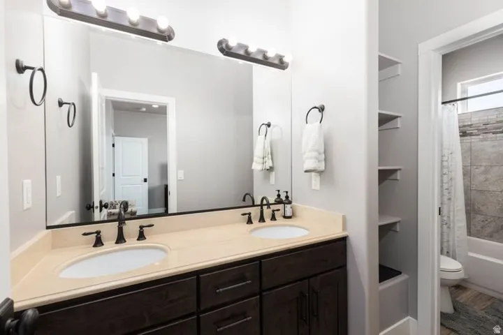 Dual vanity with light-toned countertop, two undermount sinks, and matte black fixtures