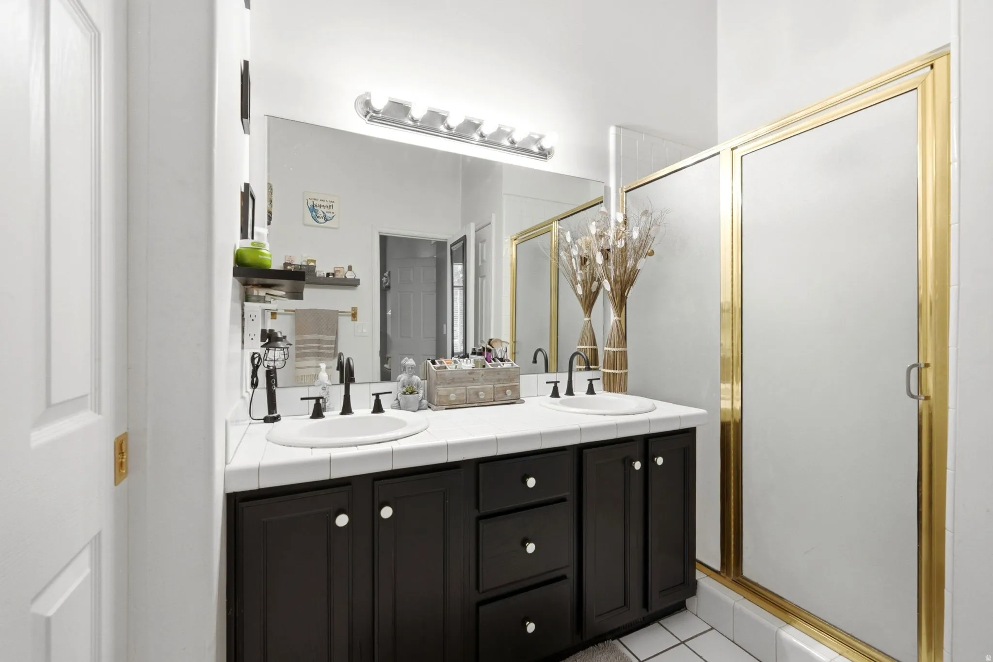 Dual vanity with dark wood-finish cabinetry, white tile countertop, and integrated sinks