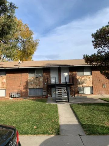Brick exterior with stone accents, individual unit entrances, and an exterior metal stairway