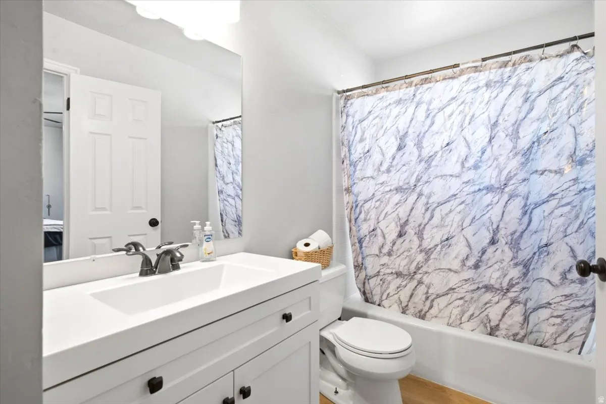 White vanity with black hardware, integrated sink, and wall-mounted mirror