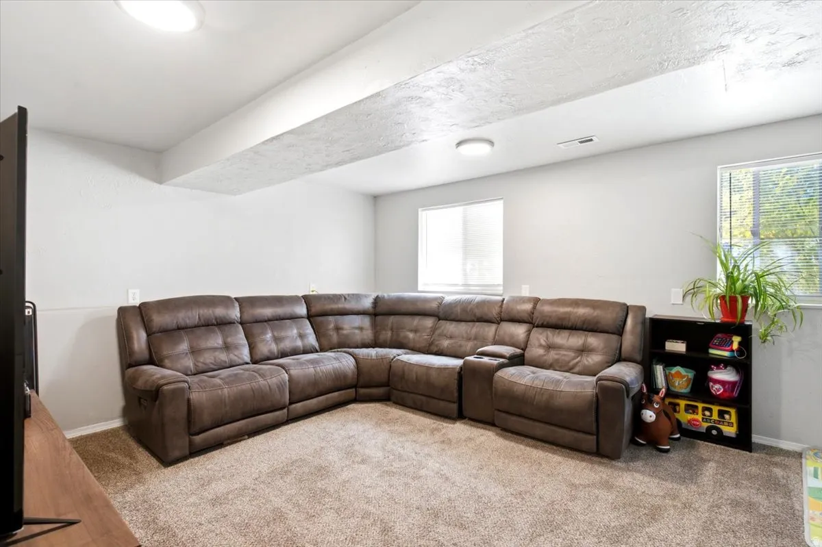 Carpeted room featuring multiple windows, recessed ceiling lighting, and light-toned walls