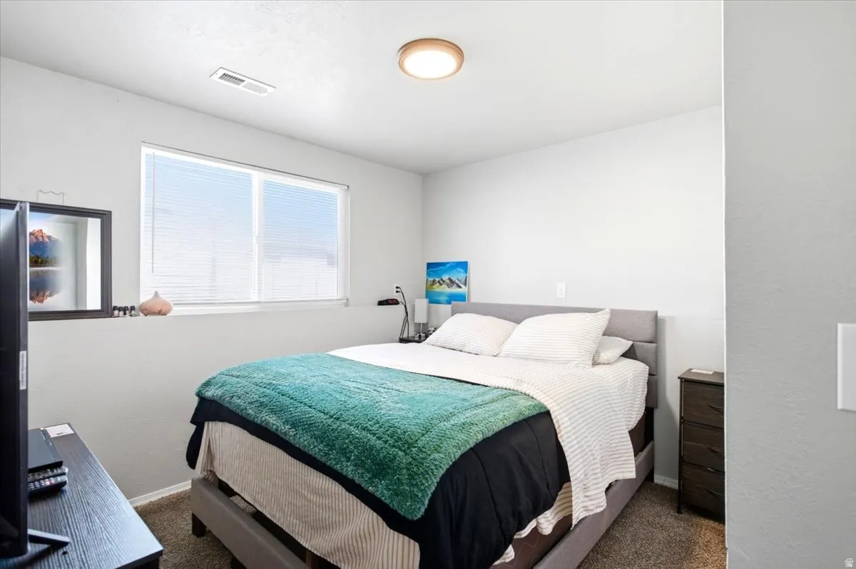 Wall-to-wall carpeting, window with blinds, and ceiling-mounted light fixture