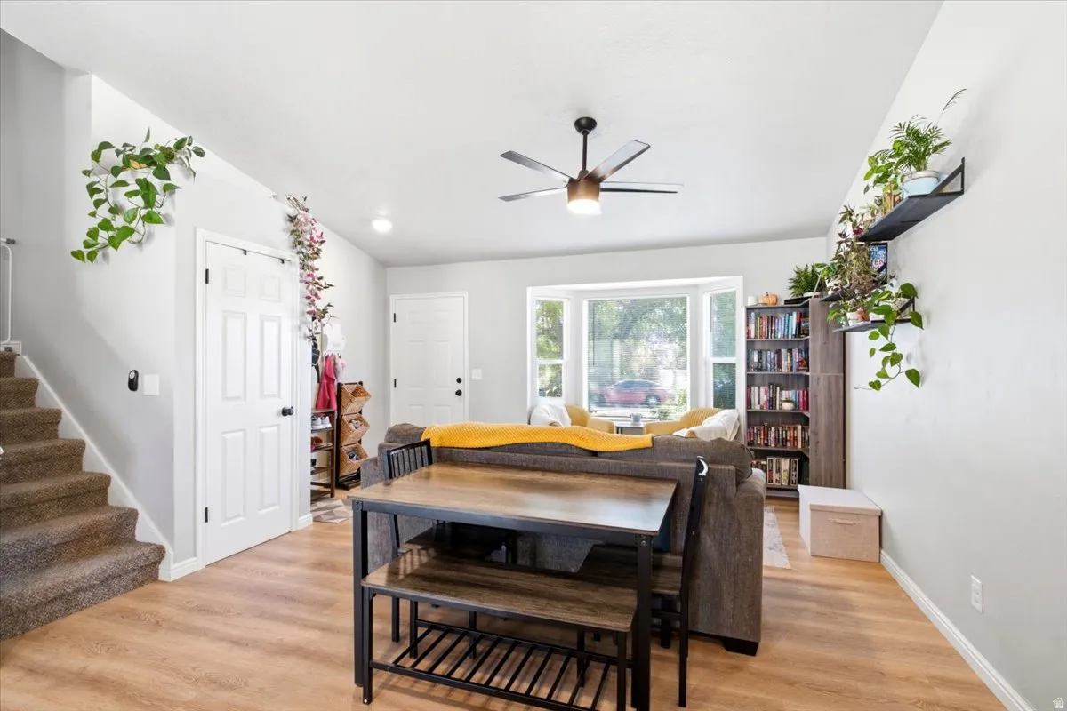 Light wood-finish flooring throughout, complemented by a ceiling fan with integrated lighting