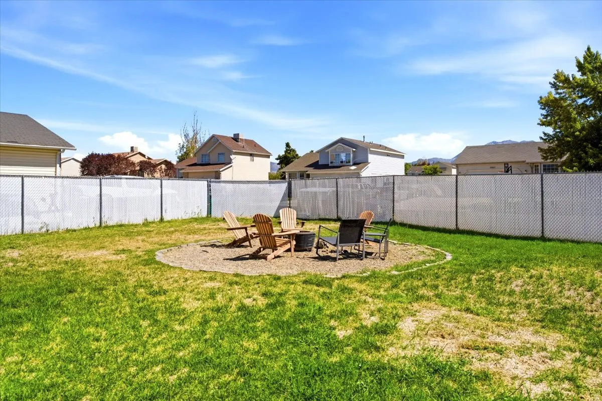 Expansive lawn area featuring a circular gravel fire pit pad