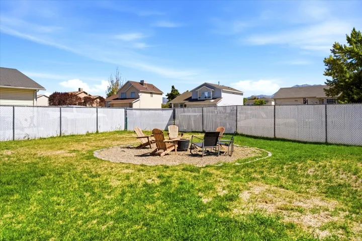 Expansive lawn area featuring a circular gravel fire pit pad