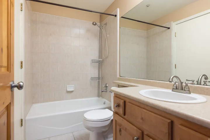 Vanity with wood-finish cabinetry, integrated sink, and brushed nickel faucet