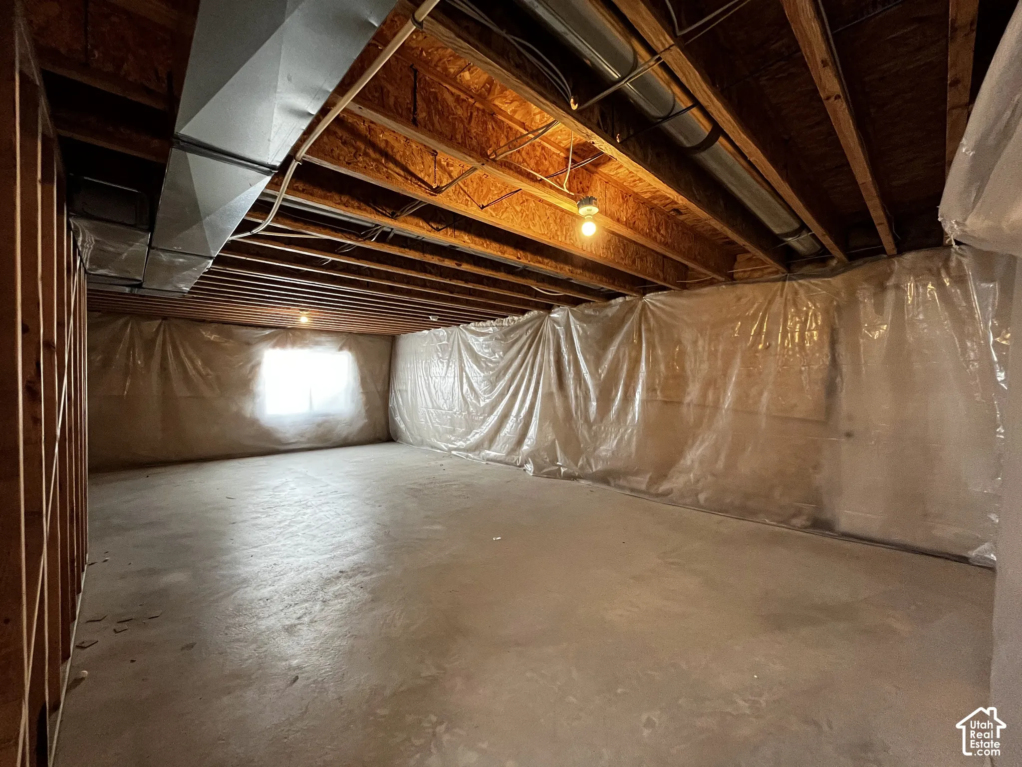 Unfinished basement featuring exposed wood joists, concrete flooring, and visible ductwork