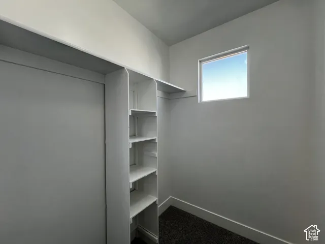 Built-in shelving, white walls, and a single window with white trim