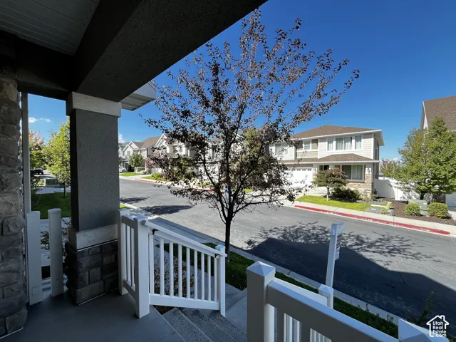 Covered porch with stone column base and white railing