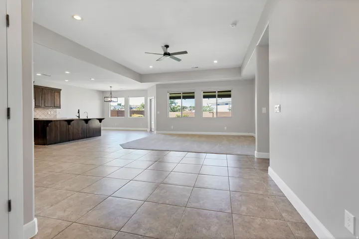 Tile flooring, recessed lighting, ceiling fan, dark wood-finish cabinetry, and multiple windows