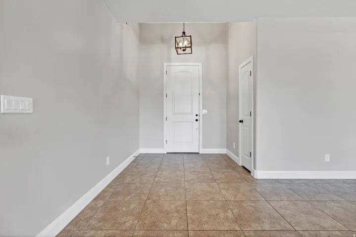 Foyer featuring neutral tile flooring, white baseboards, and a contemporary ceiling-mounted light fixture
