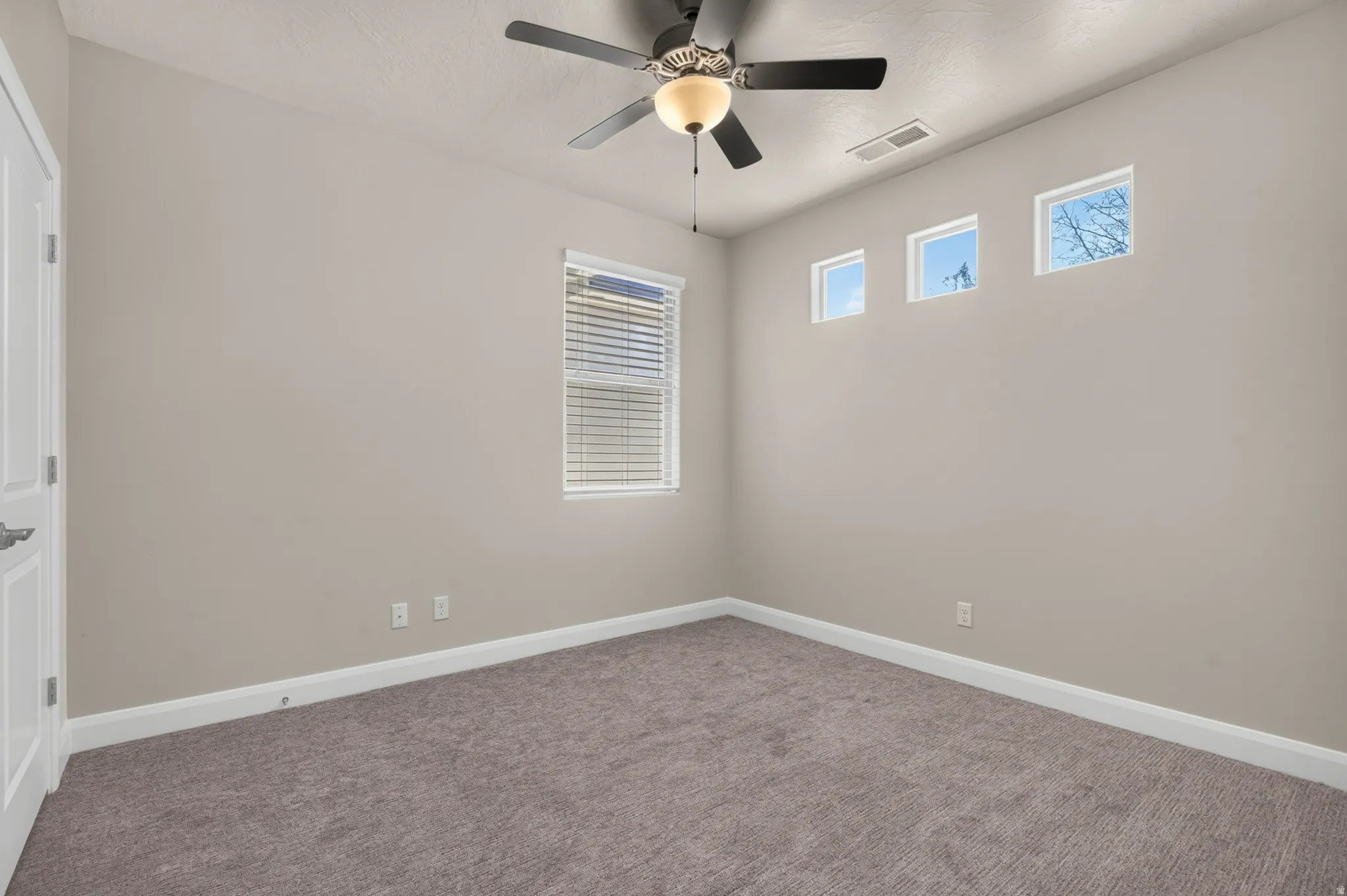 Recessed lighting, ceiling fan with light fixture, carpeted flooring, window with blinds, and three upper square windows
