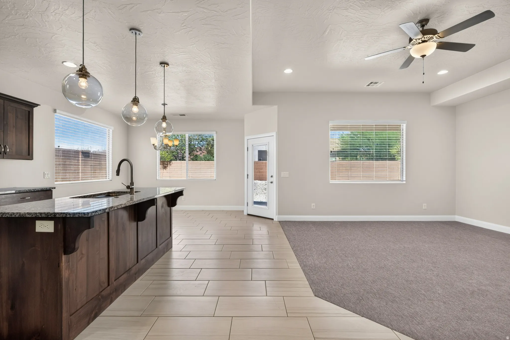 Kitchen island with dark wood cabinetry and stone-finish countertop