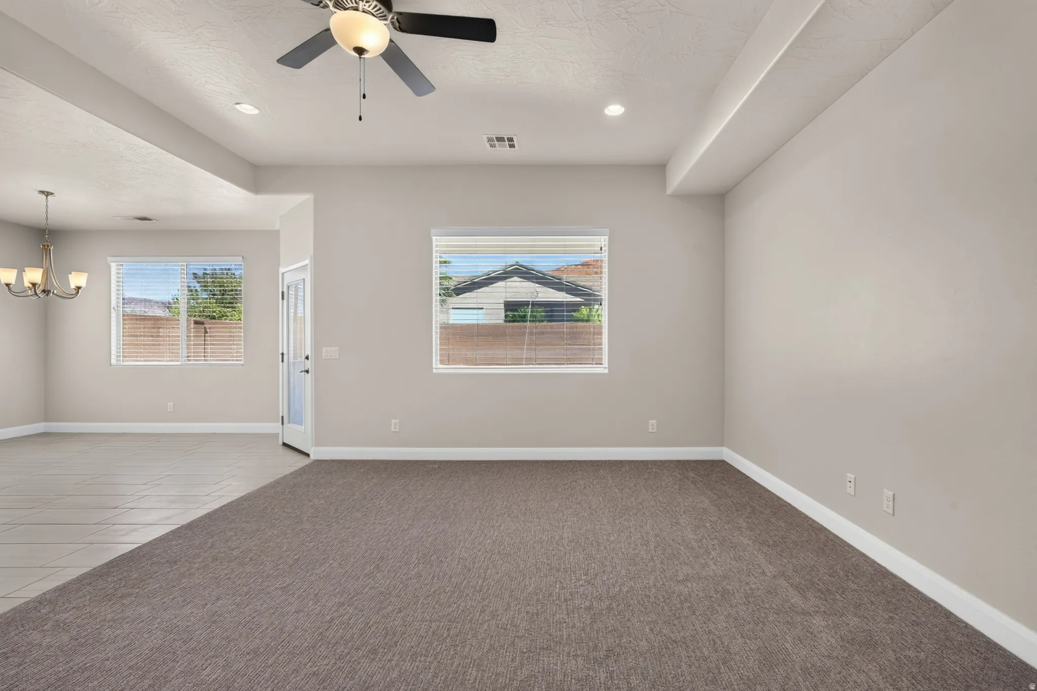Open-concept living space featuring recessed lighting, a ceiling fan with light fixture, and warm gray carpeting
