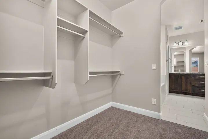 Built-in closet shelving, integrated hanging rods, and plush carpet flooring
