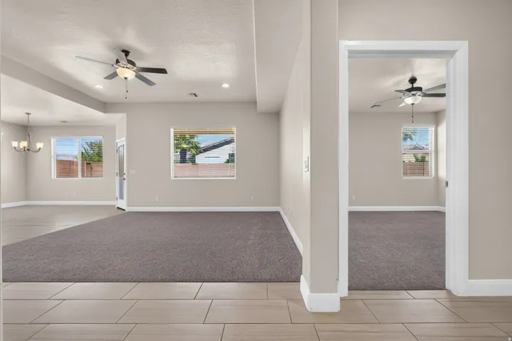 Neutral tone walls with recessed lighting and ceiling fans
